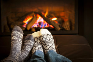 Couple wearing socks by fireplace on Christmas